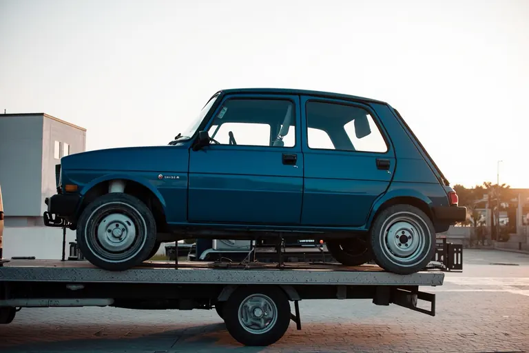 Coche sobre la plataforma de un vehículo de transporte